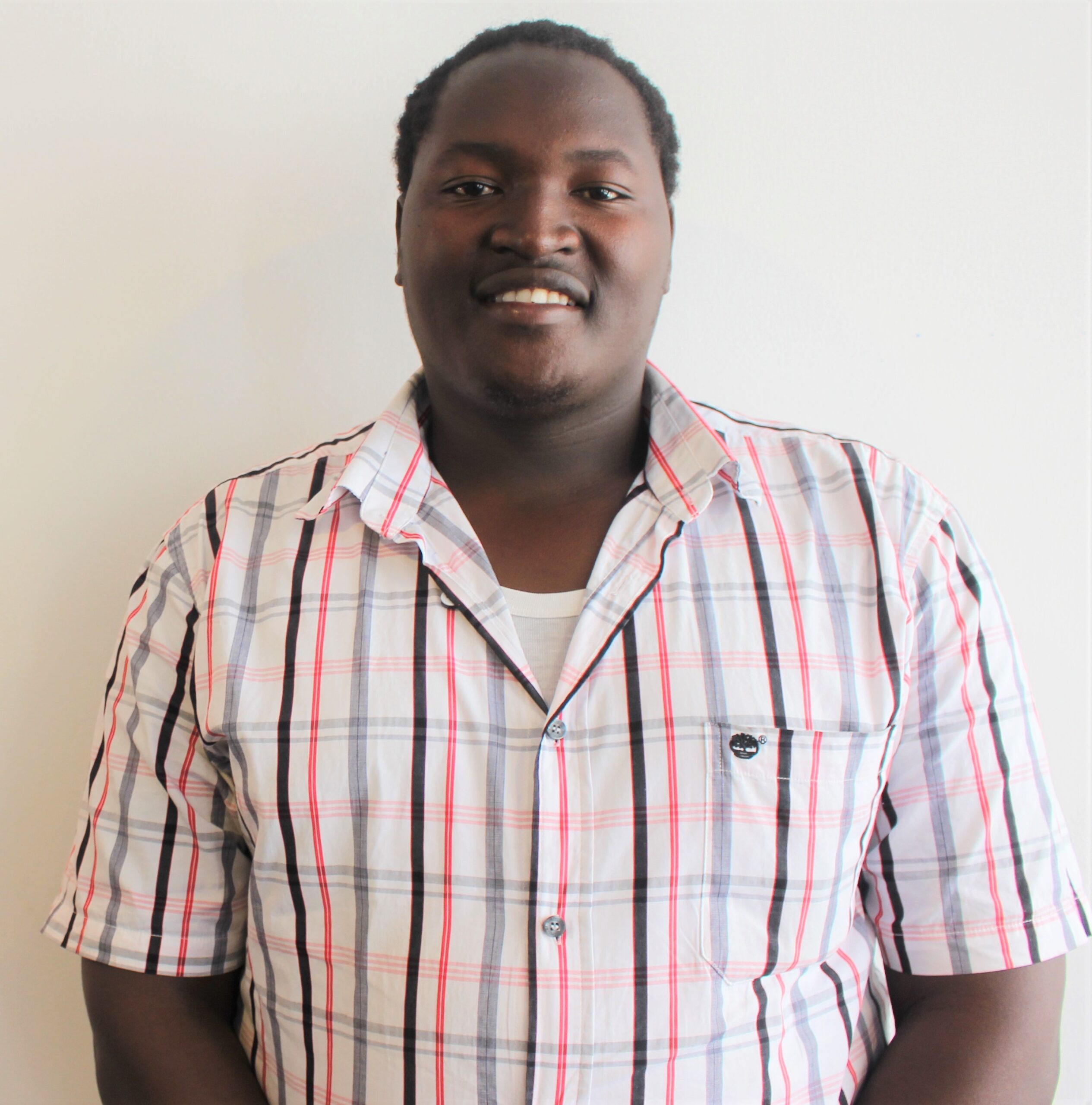 A young Tanzanian man smiling at the camera