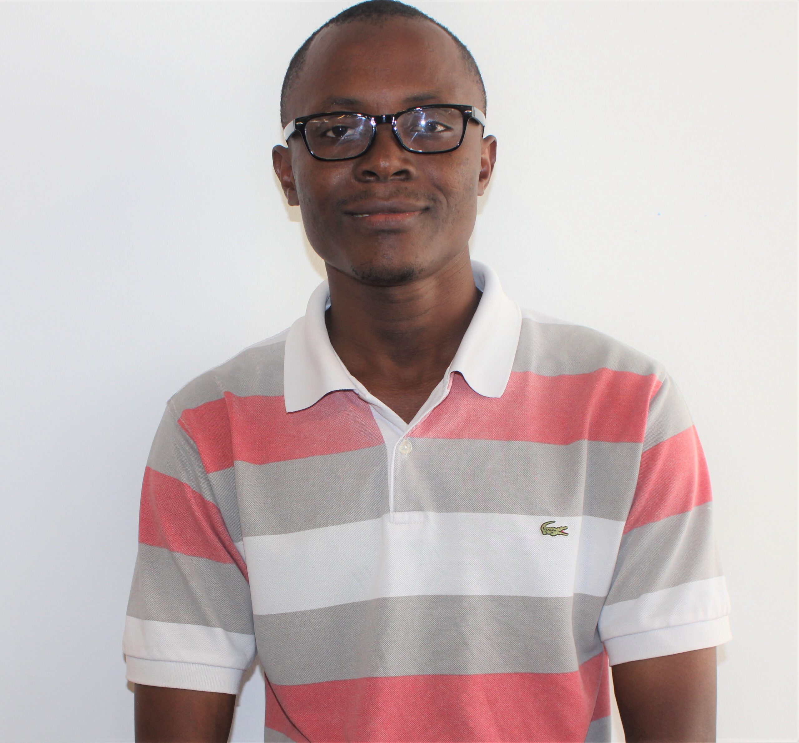 A young Tanzanian man smiling at the camera