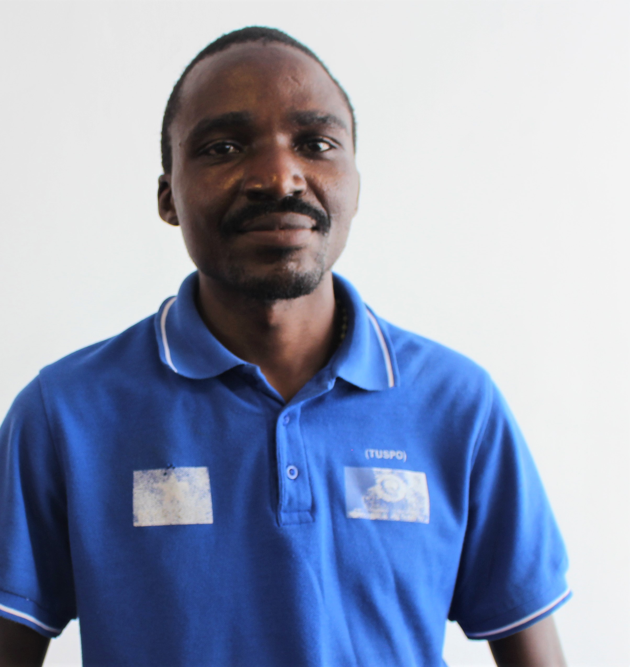 A young Tanzanian man smiling at the camera