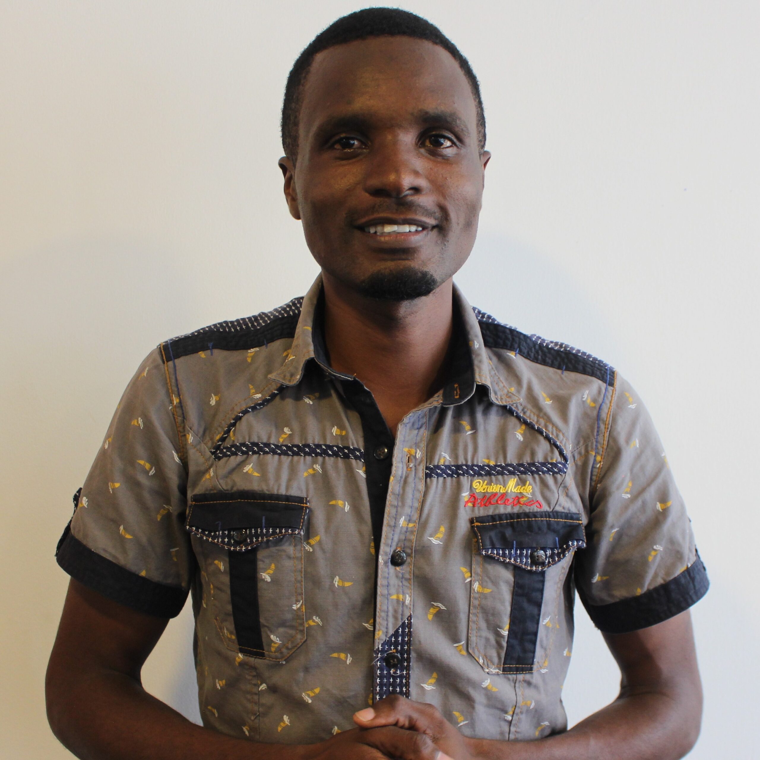 A young Tanzanian man smiling at the camera